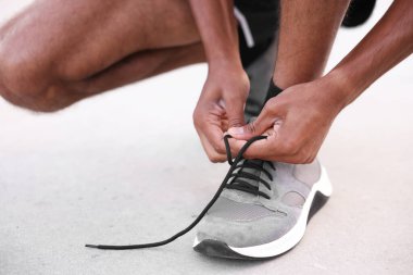 Spor ayakkabısının bağcığını bağlayan koşucu, yakın plan.