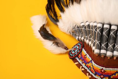 Traditional warbonnet (Native American chief headdress) on yellow background, closeup