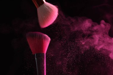 Siyah arka planda pembe göz farlı makyaj fırçaları, yakın plan. Metin için boşluk