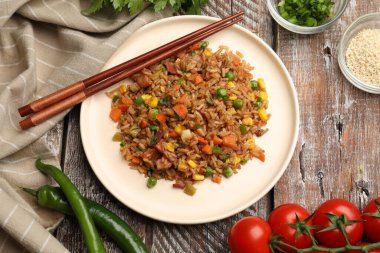 Tahta masada servis edilen sebzeli pilav ve domuz pastırması.