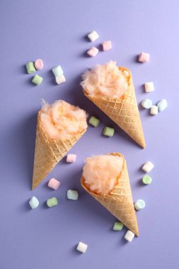 Waffle külahında pamuk şeker ve menekşe arka planda marşmelov.