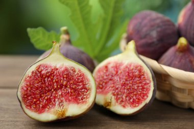 Taze incir ve yeşil yaprak dışarıda, ahşap masada, yakın plan.