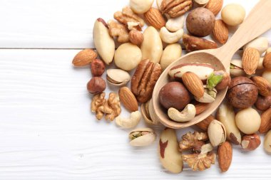 Farklı fındık ve kaşık karışımı beyaz ahşap masa, düz yatıyordu. Metin için boşluk