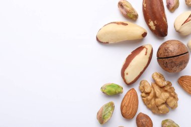Beyaz arka planda farklı fındıkların karışımı, düz yatış. Metin için boşluk