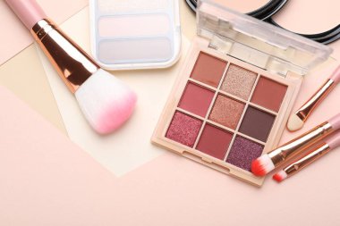 Renkli göz falı paletleri ve arka planda makyaj fırçaları, düz yatış. Metin için boşluk