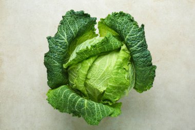 Açık gri masada taze Savoy lahanası, üst manzara.