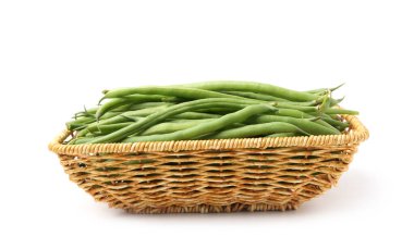 Hasır sepetteki taze yeşil fasulye kabukları beyaza izole edilmiş.