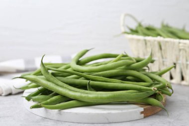 Fresh green bean pods on grey table, closeup