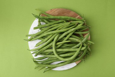 Fresh bean pods on green background, top view