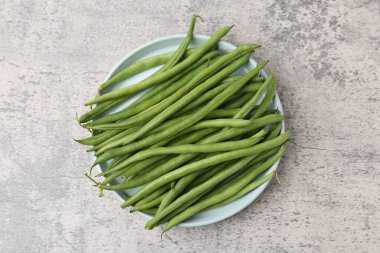 Gri desenli masa üzerinde taze yeşil fasulye kabukları.