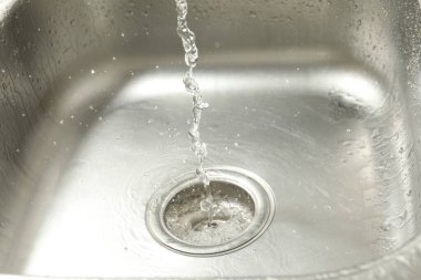 Water going down sink drain, closeup view