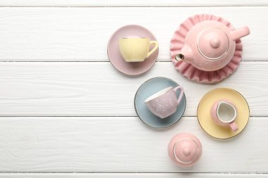 Beyaz ahşap masadaki çocuklar için seramik çay seti. Metin için boşluk
