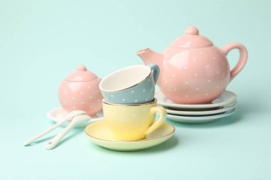 Turkuaz arka plandaki çocuklar için güzel seramik çay seti, yakın plan.