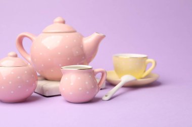 Menekşe arka plandaki çocuklar için güzel seramik çay seti, yakın plan.