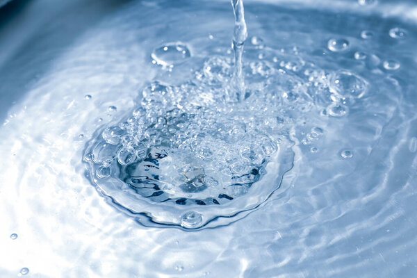 Water going down sink drain, closeup view