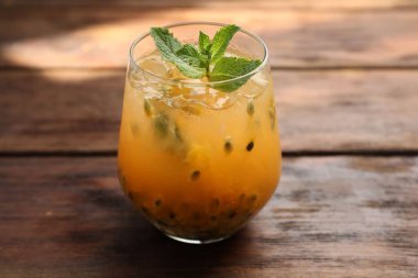 Ahşap masadaki nane şekerli, nefis çarkıfelek meyveli içecek.