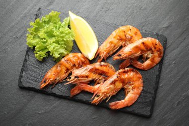Siyah masada limonlu ve marullu ızgara karides. Lezzetli deniz ürünleri yemeği.
