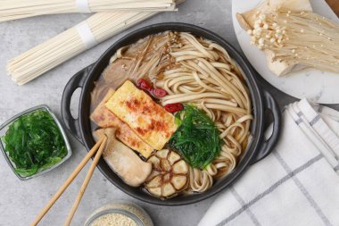 Açık gri masa üzerinde Enoki ve Kral istiridye (eryngii) mantarlı lezzetli ramen.