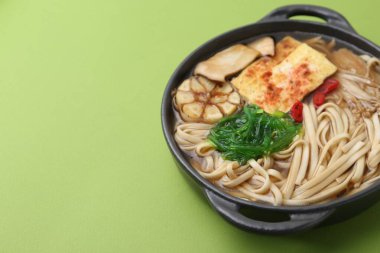 Yeşil arka planda Enoki ve Kral istiridye (eryngii) mantarlı lezzetli ramen, yakın plan. Metin için boşluk