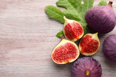 Taze incir ve ahşap masada yeşil yaprak. Metin için boşluk