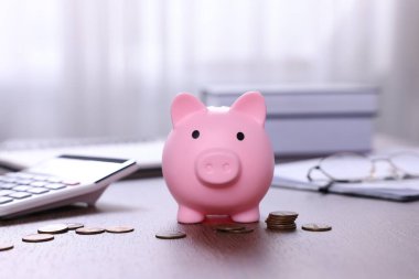 Domuz kumbarası, hesap makinesi ve paralar kapalı masa üzerinde, seçici odak