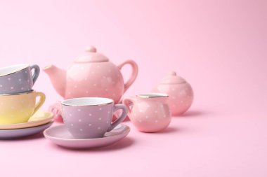 Pembe arka planda güzel çay seti, mesaj için yer. Çocuk oyuncağı