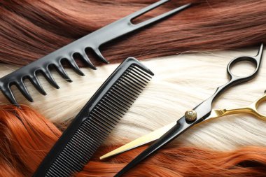 Farklı güzel saç telleri, taraklar ve kuaför makası.