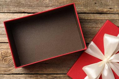 Güzel kapaklı, ahşap masa manzaralı bir hediye kutusu.