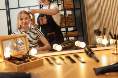 Profesyonel kuaför müşteriyle kuaförde çalışıyor.