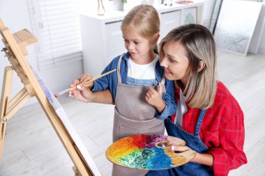 Meslek seçimi. Anne kızına stüdyoda resim yapmayı öğretiyor.