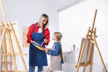 Meslek seçimi. Anne kızına stüdyoda resim yapmayı öğretiyor.