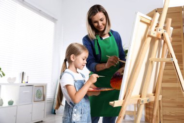 Meslek seçimi. Anne kızına stüdyoda resim yapmayı öğretiyor.