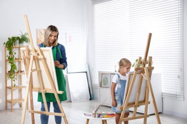 Meslek seçimi. Anne kızına stüdyoda resim yapmayı öğretiyor.