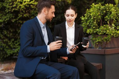 Paket kahve. Dışarıdaki bankta kağıt bardak içen iş adamları.