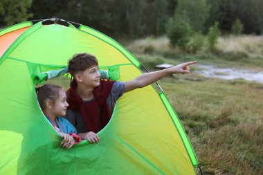 Erkek kardeşi kamp çadırında kız kardeşini işaret ediyor.