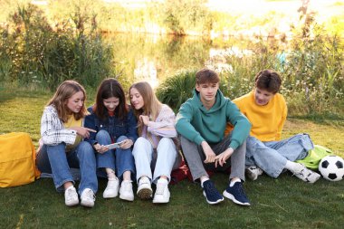 Bir grup genç parkta birlikte vakit geçiriyorlar.