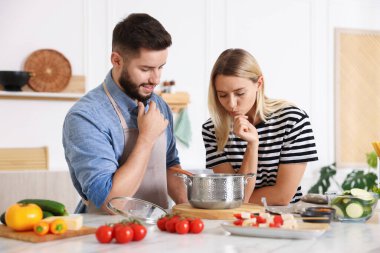 Mutfakta birlikte yemek pişiren çift.