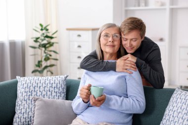 Evlatlar annelerine bardakla sarılıyorlar.