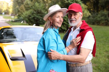 Modern Cabriolet yakınlarında şık bir yaşlı çift.