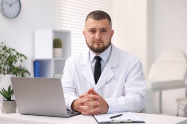 Klinikte dizüstü bilgisayarla çalışan bir doktor. Online tıbbi danışmanlık