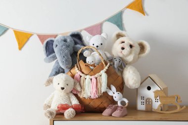 Beyaz duvarın yanındaki ahşap masada farklı oyuncaklar.