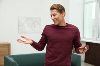 Gözlükler ve kontak lensler arasında seçim yapan bir adam.