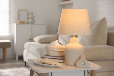 Süslü lamba, dekor ve beyaz masa üzerine kitap.