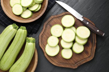 Taze olgun kabaklar, siyah desenli masa üzerinde bıçak, düz uzanmış. Tam ve kesin.