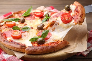 Peynirli, salamlı, domatesli ve zeytinli leziz pizzayı yakın plan.