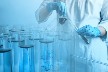 Laboratuvar analizi. Cam eşyalar üzerinde çalışan bir bilim adamı, test tüpleriyle çifte maruz kalma.