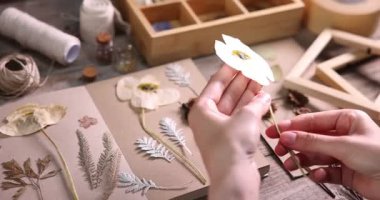 Kuru çiçekli ve defterli kadın ahşap masada, yakın plan.