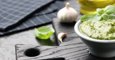 Taze pesto sosu ve malzemeler siyah masada, yakın plan. Kamera sağa hareket ediyor