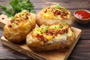 Tahta masada servis edilen lezzetli fırınlanmış patatesler, yakın plan.