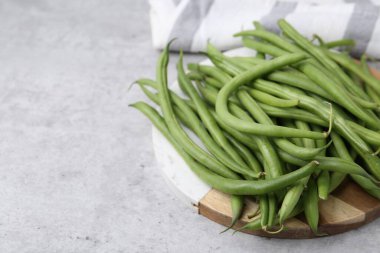 Fresh green bean pods on grey table, closeup. Space for text